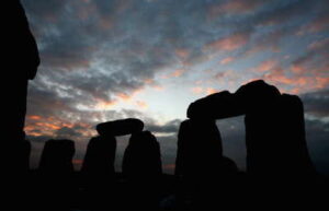Stonehenge at sunrise with ancient standing stones silhouetted against a colorful morning sky.