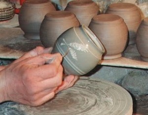 Potter decorating a clay vessel on a pottery wheel